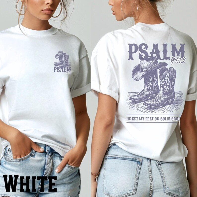 K&ouml;nnte beinhalten: Wei&szlig;es T-Shirt mit einer lilafarbenen Grafik von Cowboystiefeln und einem Hut. Der Text "PSALM 40:2" und "HE SET MY FEET ON SOLID GROUND" ist auf dem Shirt aufgedruckt.