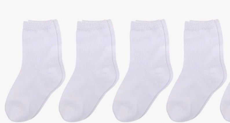May include: A collection of white ankle socks, arranged in a row. The socks are made of a soft, knitted material and have a ribbed cuff at the top. The socks are a solid white color.