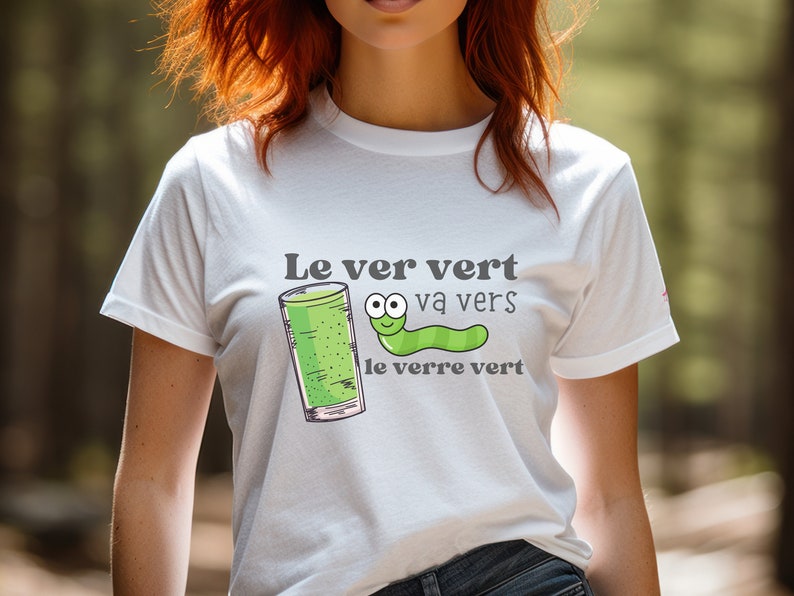 Puede incluir: Camiseta blanca con un gusano verde y un vaso de l&iacute;quido verde. El texto en la camiseta dice "Le ver vert va vers le verre vert".