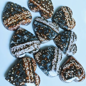 May include: Nine heart-shaped polished stones with a brown, white, and black speckled pattern.