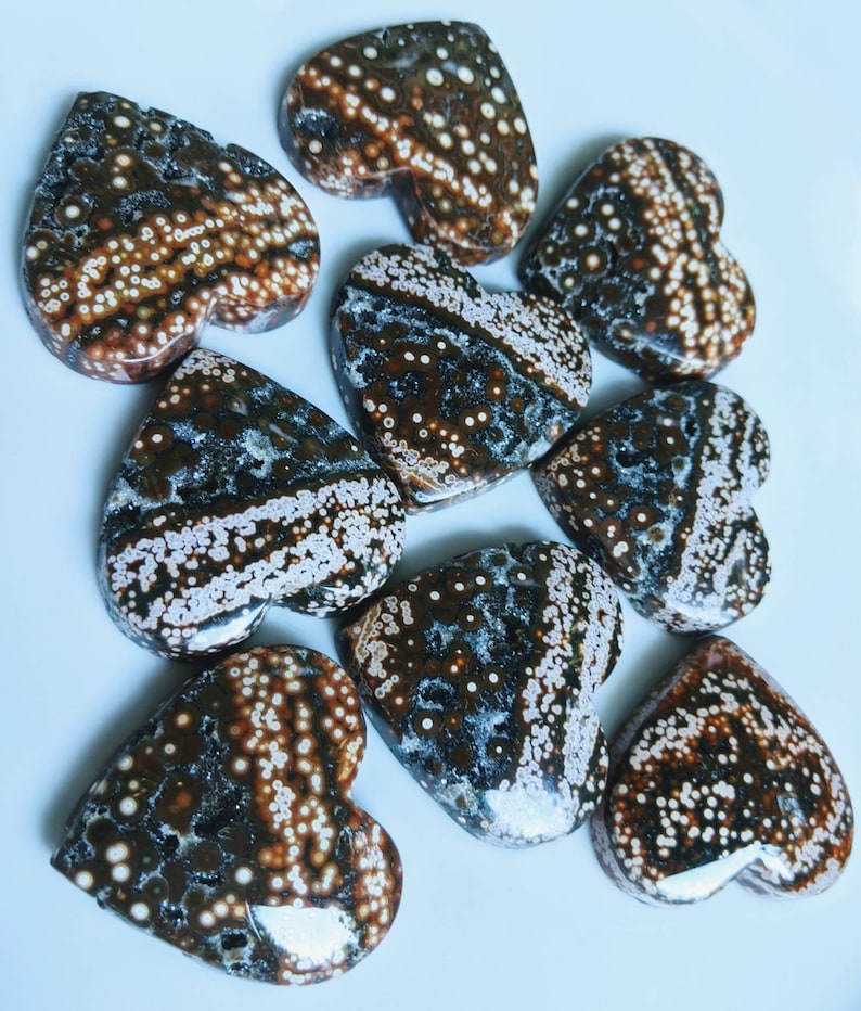 May include: Nine heart-shaped polished stones with a brown, white, and black speckled pattern.
