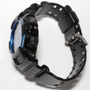 May include: Black digital watch with a blue accent around the face. The watch has a black band with a buckle closure. The watch is designed for sports and outdoor activities.