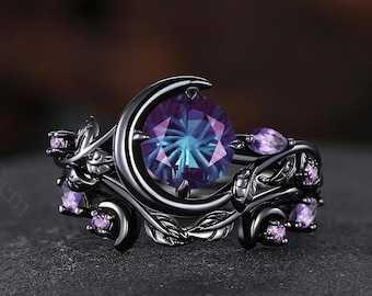 May include: A black ring with a large, round, color-changing gemstone at the center. The ring features a crescent moon design and is adorned with smaller purple gemstones and leaf-like details. The ring is set against a dark background.