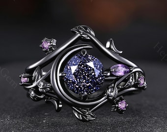 May include: Black ring with a crescent moon design and a large, sparkly, dark blue gemstone. The ring is adorned with smaller, purple gemstones and intricate floral details.