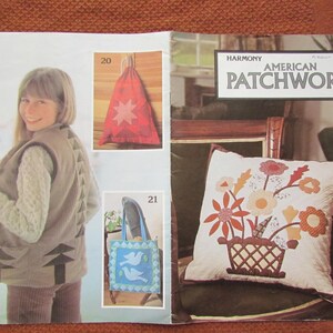 Puede incluir: Una página de la revista "Harmony American Patchwork". La página presenta a una mujer con un chaleco con diseño de flechas, una bolsa roja con cordón y una estrella, un bolso tote azul con palomas y un cojín floral.