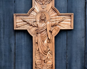 May include: A wooden carved cross with a detailed depiction of Jesus Christ with outstretched arms, surrounded by a halo and rays of light. A dove is carved above Jesus, symbolizing the Holy Spirit.