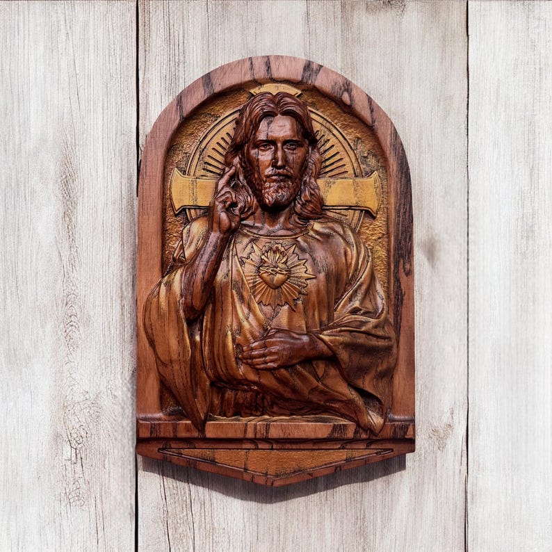 Op de afbeelding: Een houten beeldhouwwerk van Jezus Christus met een gouden hart op zijn borst. Het beeldhouwwerk is ingelijst in een houten lijst met een gouden achtergrond.