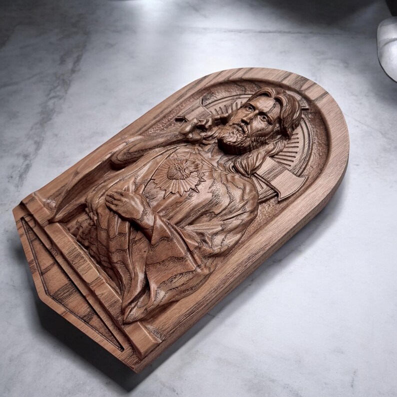 Op de afbeelding: Een houten wandsculptuur van Jezus Christus met een hart op zijn borst. De sculptuur is gedetailleerd gesneden en heeft een warme bruine kleur.