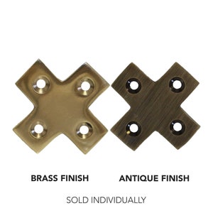 May include: Two brass corner brackets, one with a polished brass finish and the other with an antique brass finish. The brackets are shaped like an 'X' with four holes in each corner.