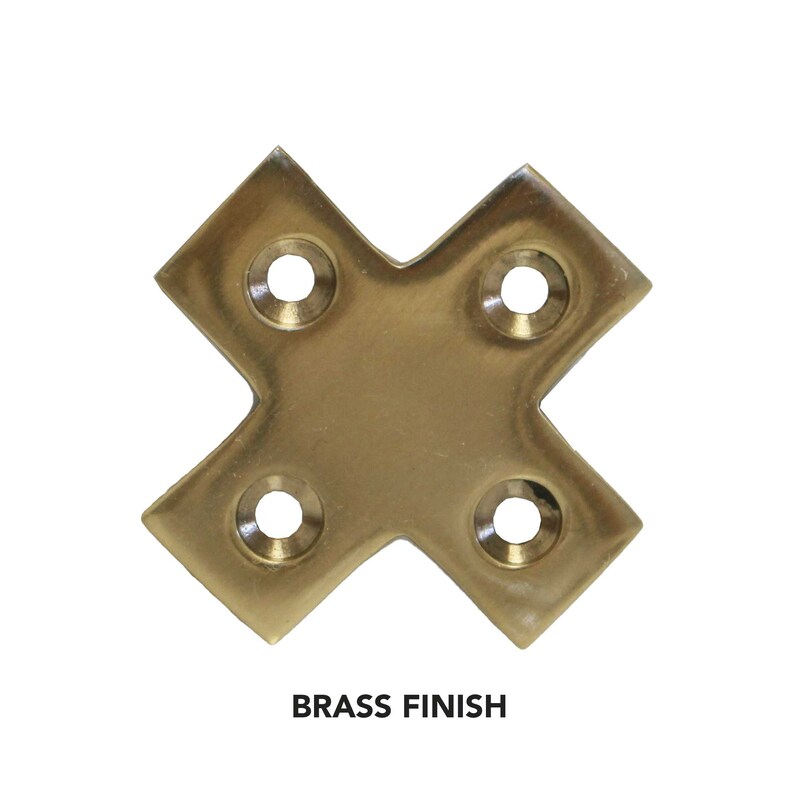 May include: Brass corner brace with four screw holes. The brace is in the shape of an 'X' and has a polished finish.