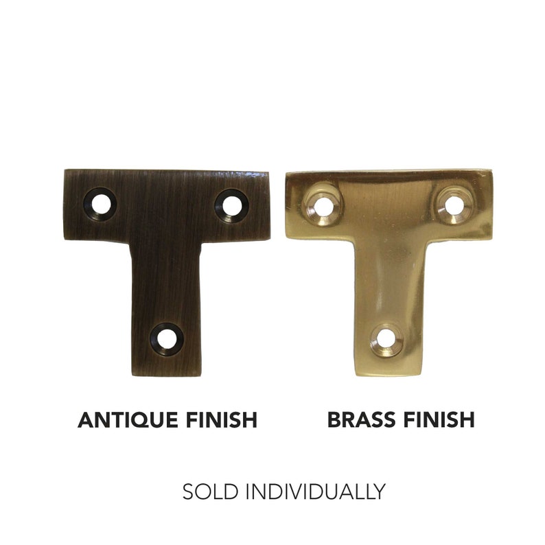 May include: Two T-shaped metal brackets, one in antique brass finish and one in polished brass finish.  The brackets are sold individually.  "Sold Individually" text is below the brackets.