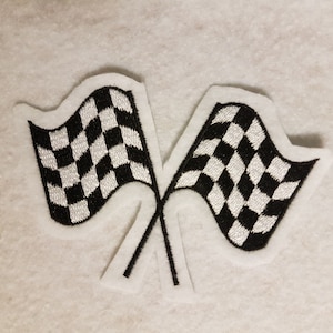 Könnte beinhalten: Zwei schwarz-weiße karierte Rennflaggen, die sich überkreuzen. Die Flaggen sind gestickt und haben einen weißen Hintergrund.