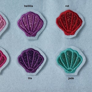 Könnte beinhalten: Zehn verschiedene farbige Glitzermuscheln mit den Wörtern gold, rosa, helllila, rot, wasser, orange, silber, pink, lila, jade, blau unter jeder Muschel.