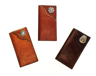 May include: Three leather wallets in different colours, each with a metal star or horseshoe accent. The wallets have a western design.
