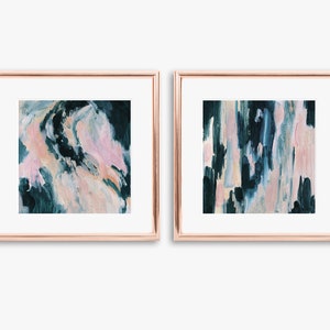 May include: Two framed abstract paintings with a teal and pink color scheme. The paintings are in gold frames and are hanging on a white wall.
