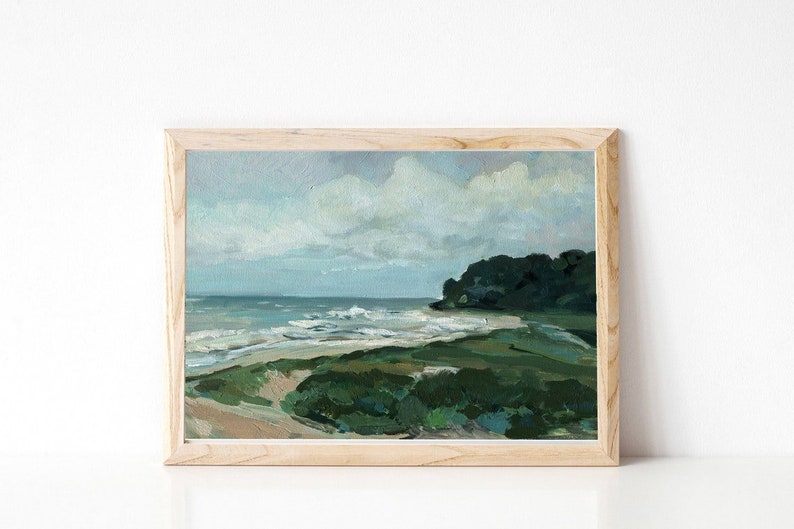 May include: A framed painting of a seascape with a green grassy shore, blue water, and white clouds in the sky.