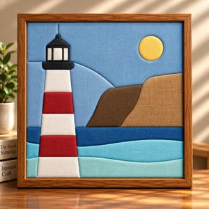 May include: A square framed fabric wall art piece featuring a lighthouse with red and white horizontal stripes, a black top, a yellow sun, brown cliffs, and layered blue ocean waves. The scene is constructed from textured fabric panels.