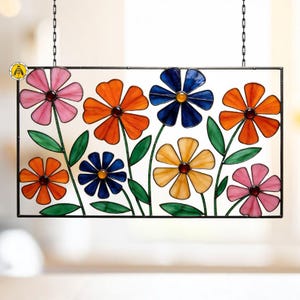 Peut inclure: Un panneau rectangulaire en vitrail représentant des fleurs colorées. Les fleurs sont dans des tons de rose, orange, bleu et jaune, avec des feuilles et des tiges vertes. Le panneau est encadré en noir et suspendu par des chaînes.