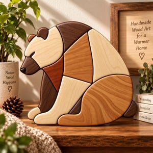 Puede incluir: Una figura decorativa de oso hecha de madera, compuesta por varias piezas entrelazadas en tonos variados de marrón claro, medio y oscuro. El oso se muestra en posición sentada, exhibiendo un acabado suave y pulido con patrones de veta de madera visibles en todo el diseño.