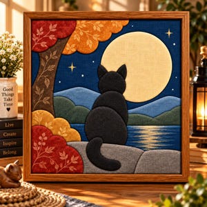 Pode incluir: Uma peça de arte de parede em tecido emoldurada retratando um gato preto sentado em uma rocha cinza, de frente para uma grande lua amarela em um céu noturno azul escuro. A cena inclui uma árvore com folhas vermelhas e laranjas e colinas.