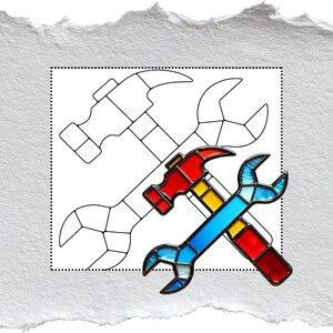 May include: A stained glass design featuring a red and yellow hammer and a blue, yellow, and red wrench. The tools are set against a white background with a dotted border and a sketched outline of the same tools.