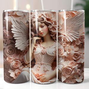 May include: Three stainless steel tumblers with a design of an angel with wings, surrounded by pink flowers. The angel is wearing a white dress with a corset-like bodice.