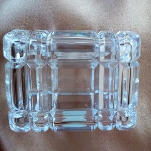 May include: A clear glass box with a geometric pattern. The box is empty and has a rectangular shape.