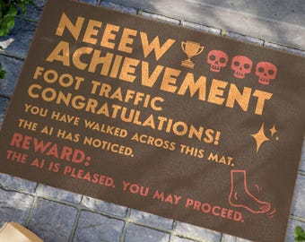 May include: A rectangular brown doormat featuring orange text that reads NEEEW ACHIEVEMENT, FOOT TRAFFIC CONGRATULATIONS, YOU HAVE WALKED ACROSS THIS MAT, THE AI HAS NOTICED, REWARD, THE AI IS PLEASED, YOU MAY PROCEED, with icons of a trophy, skulls, stars, and a foot.