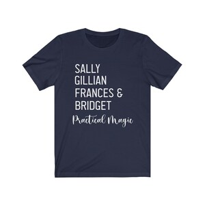 Peut inclure: T-shirt bleu marine avec texte blanc. Les noms Sally, Gillian, Frances & Bridget sont &eacute;crits, ainsi que "Practical Magic" en cursive. Un t-shirt d&eacute;contract&eacute; pour les fans du film.