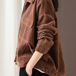 May include: A brown corduroy jacket with a button-up front and two pockets. The jacket has a relaxed fit and is made of a soft, comfortable fabric.
