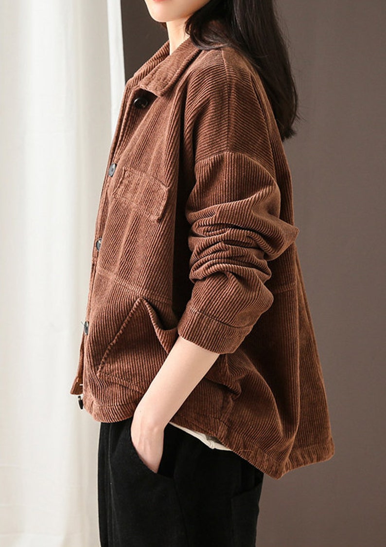 May include: A brown corduroy jacket with a button-up front and two pockets. The jacket has a relaxed fit and is made of a soft, comfortable fabric.