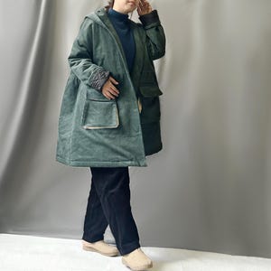 May include: A green corduroy jacket with a hood and large pockets. The jacket has a quilted lining and a contrasting fabric trim.