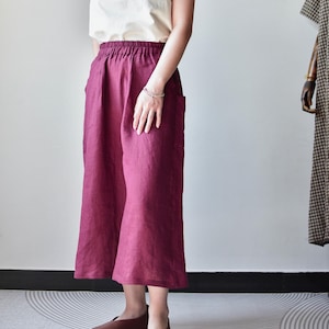 Puede incluir: Una camiseta sin mangas color crema combinada con pantalones anchos burdeos. Los pantalones tienen bolsillos y una c&oacute;moda cintura el&aacute;stica. Los zapatos planos de cuero marr&oacute;n completan el conjunto, creando un look relajado y cotidiano.