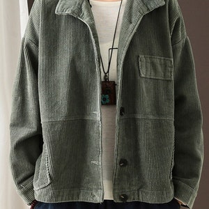 May include: A green corduroy jacket with a button fastening and a patch pocket on the left side. The jacket has a relaxed fit and a slightly cropped length.