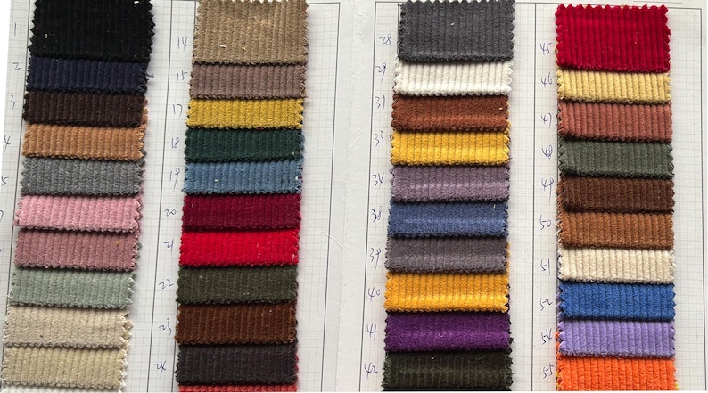 May include: A swatch card with 45 different fabric samples. The samples are arranged in rows and columns. The fabric is a corduroy material in a variety of colors, including red, blue, green, brown, and yellow.