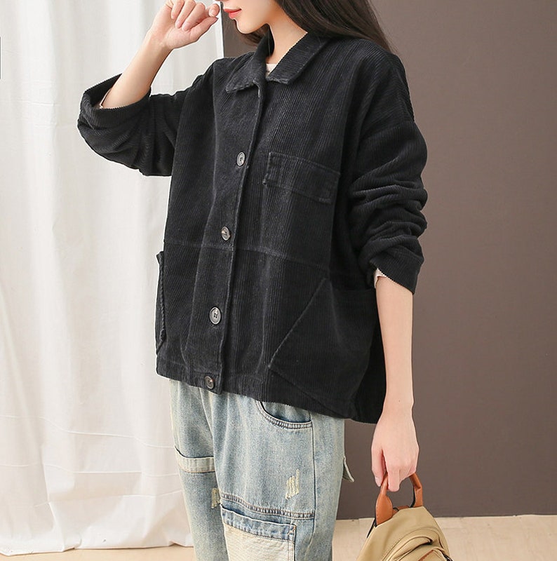 May include: A black corduroy jacket with a collared neckline, button fastening, and two patch pockets. The jacket has a relaxed fit and is made of a soft, comfortable fabric.