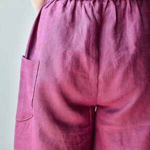 Puede incluir: Primer plano de un pantal&oacute;n de lino color magenta. El pantal&oacute;n tiene una cintura el&aacute;stica y un bolsillo en el lado izquierdo. La tela tiene un aspecto suave y texturizado.
