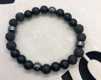 May include: A black beaded bracelet with black lava rock beads and silver metal beads.