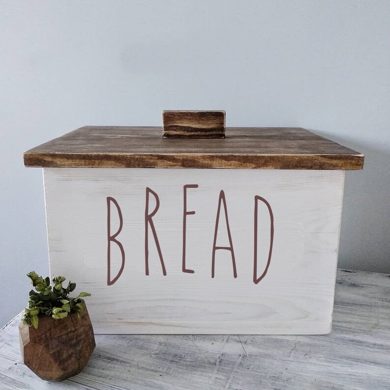 Puede incluir: Caja de pan de madera blanca con tapa de madera marr&oacute;n y pomo de madera marr&oacute;n. La parte delantera de la caja tiene la palabra "BREAD" escrita en letras marrones.
