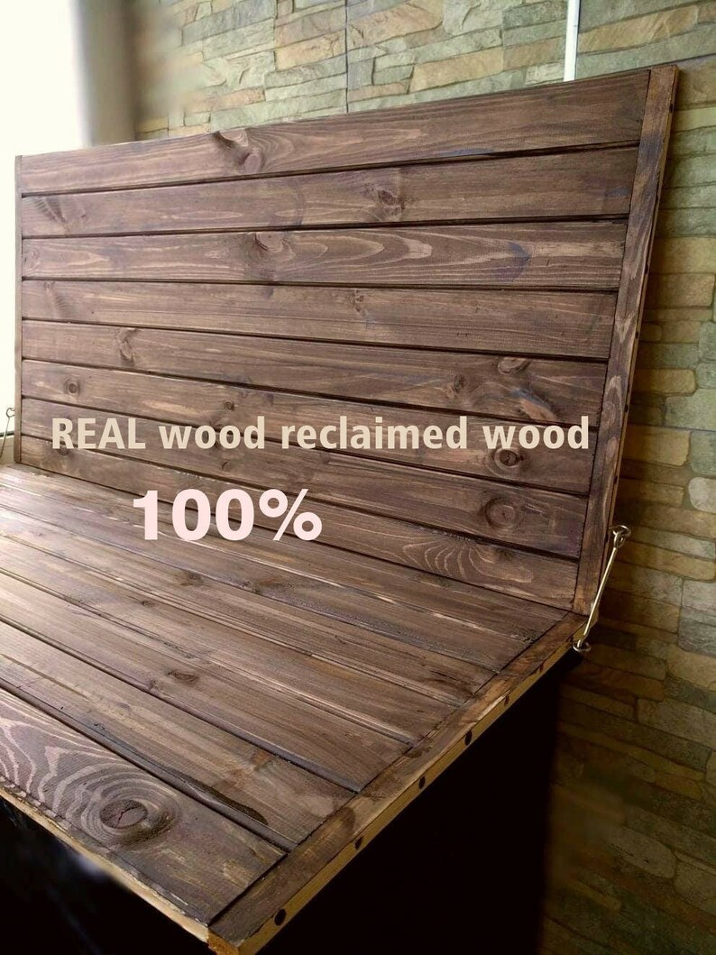May include: A dark brown wooden panel with a hinged top. The panel is made of reclaimed wood and is 100% real wood. The panel is attached to a wall with a brick pattern.
