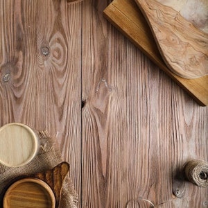 May include: A rustic wooden background with two wooden cutting boards, one round and one rectangular, and a piece of burlap fabric.