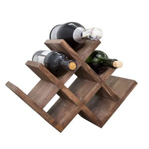 Puede incluir: Un estante de vino de madera marr&oacute;n oscuro con un dise&ntilde;o de cruz que tiene capacidad para seis botellas de vino. Se pueden ver tres botellas en la imagen.