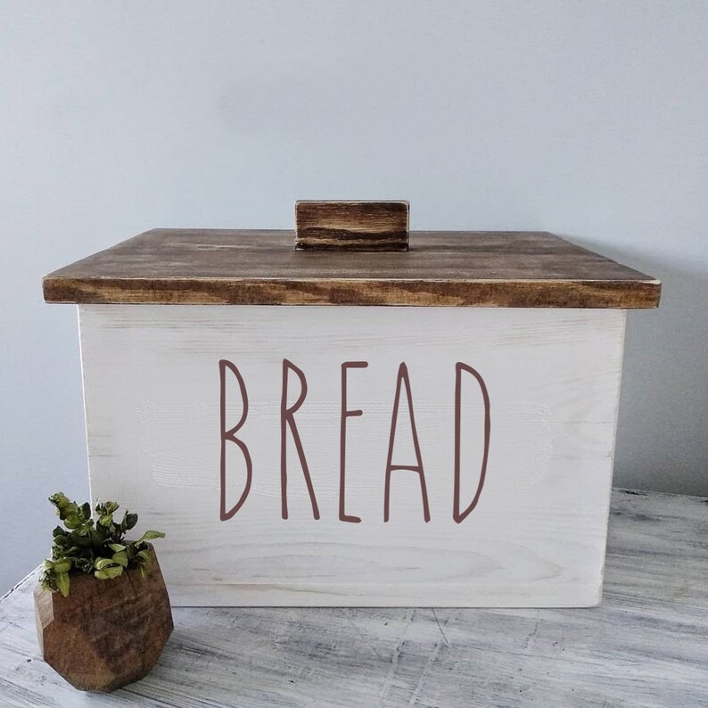Puede incluir: Caja de pan de madera blanca con tapa de madera marr&oacute;n y pomo de madera marr&oacute;n. La parte delantera de la caja tiene la palabra "BREAD" escrita en letras marrones.