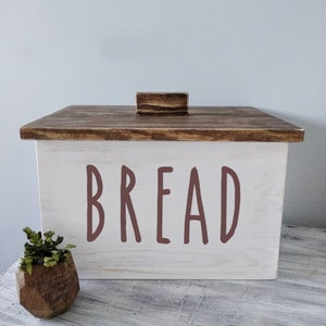 Puede incluir: Caja de pan de madera blanca con tapa de madera marr&oacute;n y pomo de madera marr&oacute;n. La parte delantera de la caja tiene la palabra "BREAD" escrita en letras marrones.