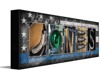 Op de afbeelding: Een gepersonaliseerd canvasprint met het woord "JONES" gespeld met behulp van afbeeldingen van militaire uitrusting. De achtergrond is een vervaagde Amerikaanse vlag met een blauwe politie streep.