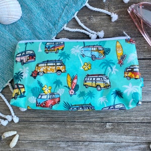 Peut inclure: Une pochette zippée turquoise avec un motif répété de fourgonnettes vintage colorées, de palmiers et de planches de surf.