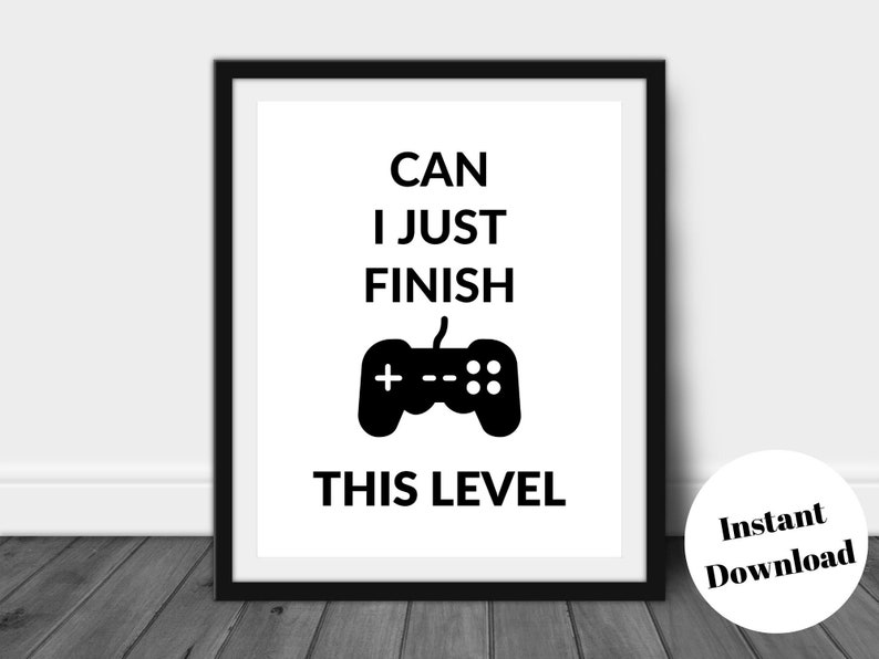 Pu&ograve; includere: Stampa con cornice nera con la scritta "CAN I JUST FINISH THIS LEVEL" e una grafica di controller nera. La stampa &egrave; su sfondo bianco. Un adesivo rotondo "Instant Download" si trova nell'angolo in basso a destra.