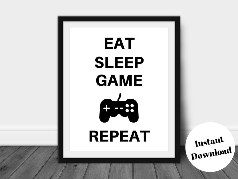 Pu&ograve; includere: Stampa con cornice nera con le parole "EAT SLEEP GAME REPEAT" in nero e un'icona di controller di gioco nera. Un cerchio bianco con "Instant Download" nell'angolo in basso a destra. Ideale per i giocatori.
