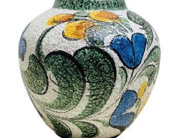 May include: A white ceramic vase with a textured surface and a floral design in shades of blue, green, and yellow.
