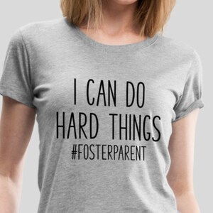 May include: A gray t-shirt with the text "I can do hard things #fosterparent" printed in black.